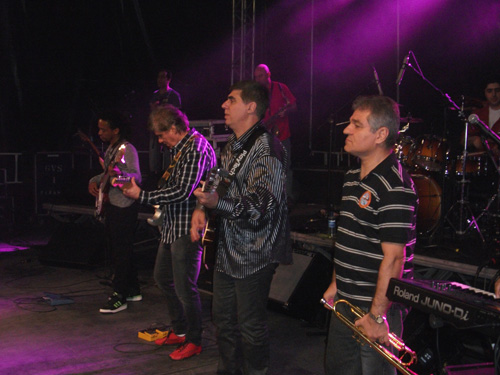 Músicos da banda alinhados no palco