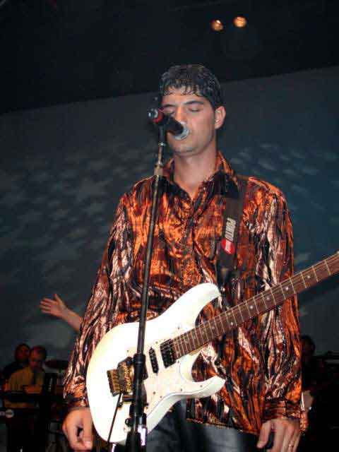 Guitarrista cantando no microfone