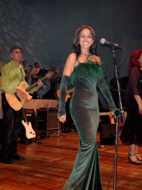 Vocalista de vestido verde no palco