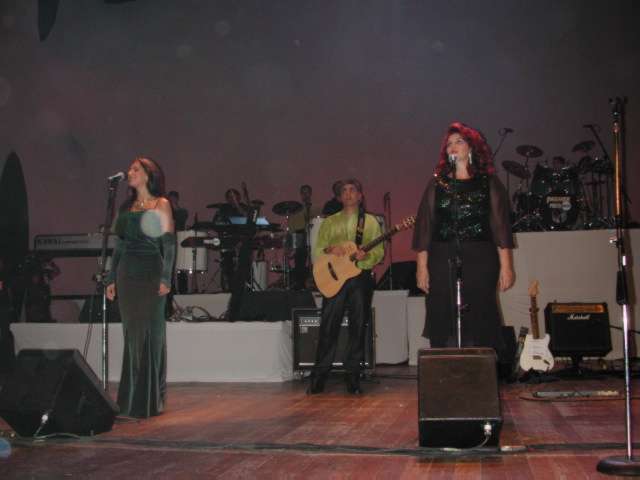 Integrantes da banda e vocalistas performando no palco