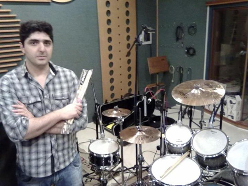 Baterista com baquetas ao lado da bateria