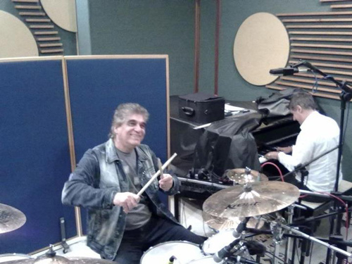 Baterista no kit e pianista ao fundo